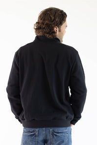 A man viewed from behind wearing a black long-sleeve quarter-zip pullover jacket and blue jeans, set against a plain white studio background.