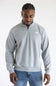A man wearing a heather grey quarter zip The North Face men's sweatshirt with a white logo on the upper left chest.