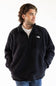 A man wearing a black fleece quarter-zip pullover by The North Face, styled over a white t-shirt and blue jeans, photographed against a plain white background.