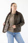 A woman modeling a dark brown leather jacket with a brown plaid lining, worn open over a beige sweater and blue jeans, against a plain white background.