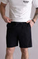 Person wearing a white t-shirt with a logo and black shorts on a plain background. The shorts are the Quiksilver Union Amphibian 20" Hybrid Shorts for Men in Black.