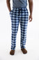 A person wearing blue and white plaid pajama pants with a drawstring waist, paired with a gray t-shirt and brown slippers, shown from the waist down on a white studio background.