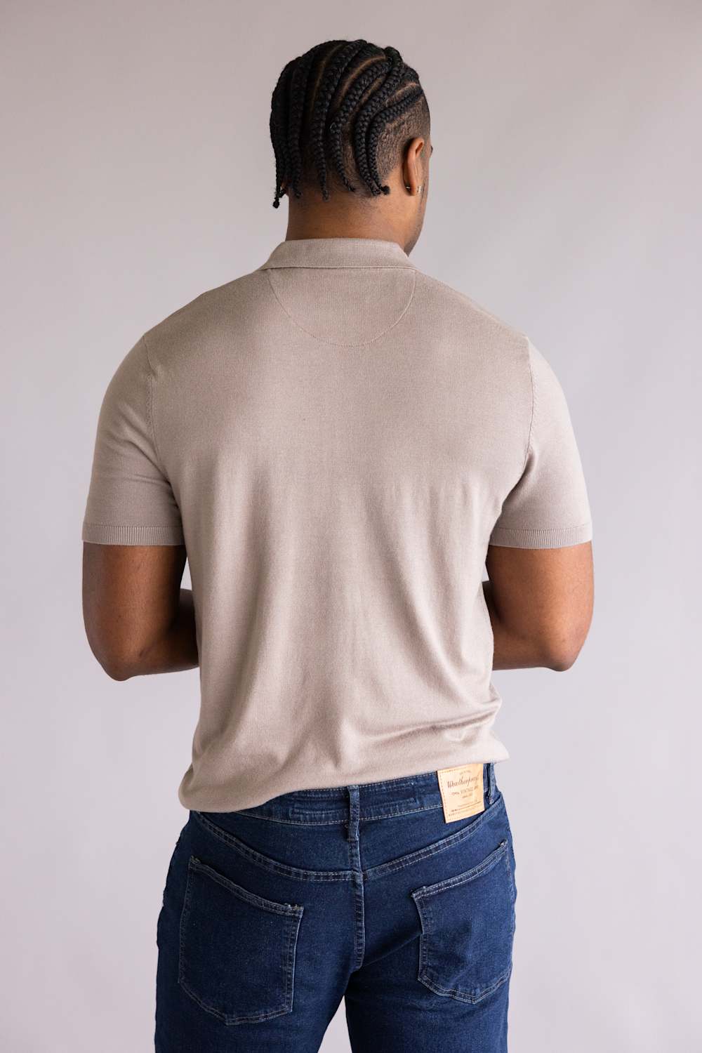 Person wearing a Denim & Flower Zip Sweater Polo for Men in Taupe and blue jeans against a plain background showing the back
