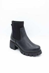 A single black ankle boot with a ribbed elastic side panel and a chunky lug sole, photographed on a clean white background.