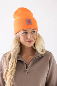 Blonde woman modeling a neon orange Carhartt beanie 
