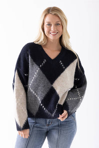 Blonde woman modeling a stylish argyle sweater 