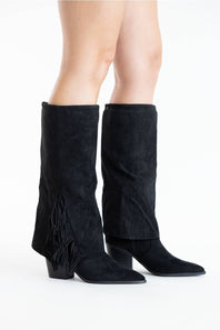 A pair of black suede knee-high boots with block heels, shown on a model's feet against a plain white studio background.