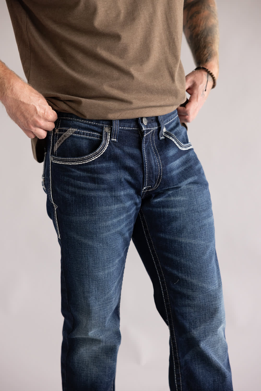 Ariat M5 Slim Stretch Coltrane Straight Leg Jeans for Men Person wearing blue jeans and a brown shirt against a plain background