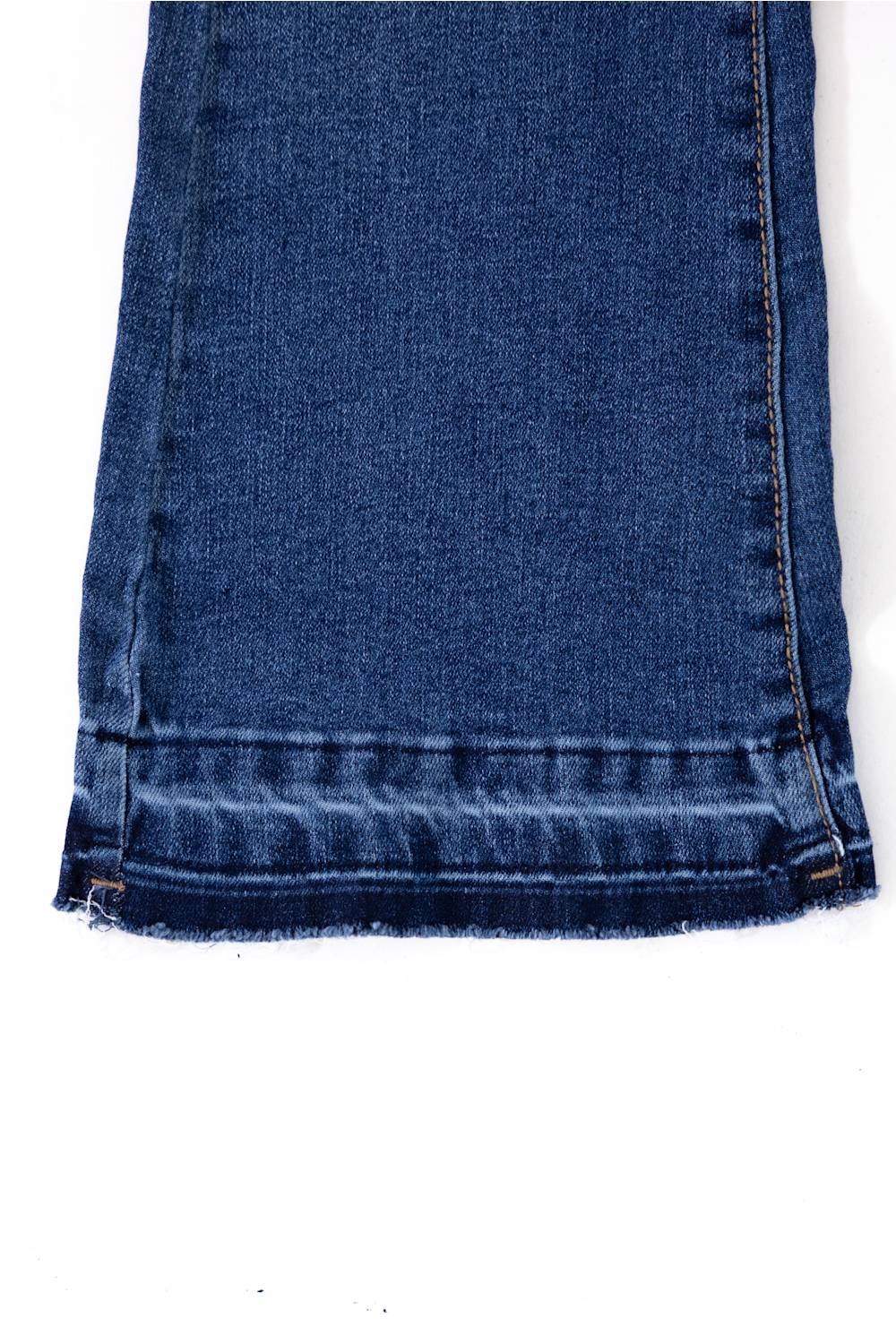 Close-up view of the raw hem line on Celebrity Pink Girls Braided Waistband Flare Jeans in Nancy medium wash