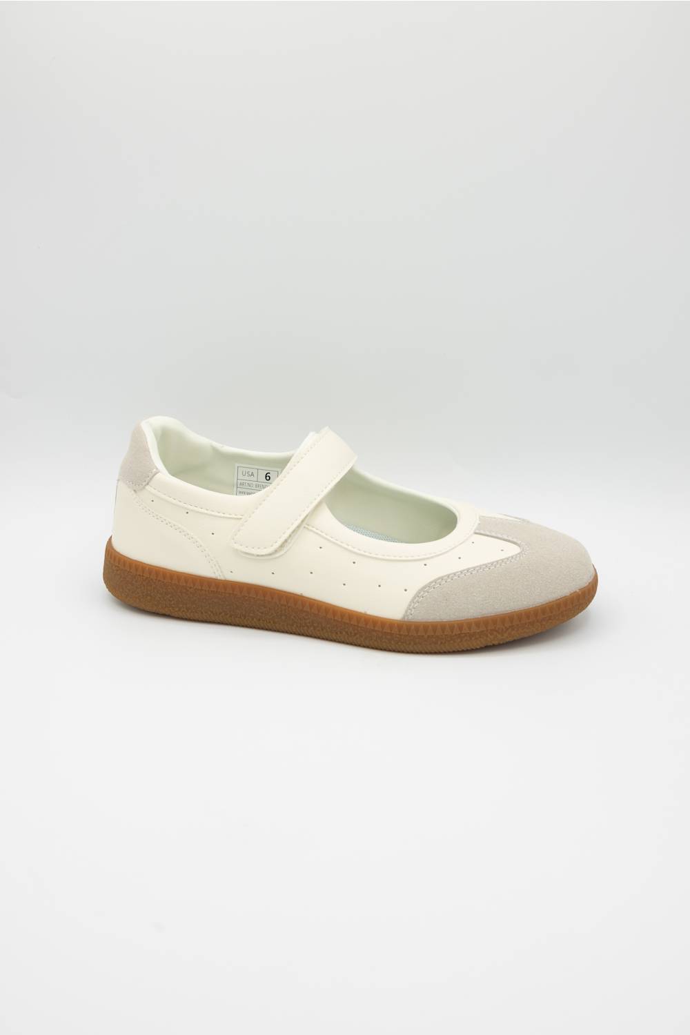 A single Mary Jane style shoe in off-white leather and suede with a brown gum sole, shown from a side profile on a light gray background.