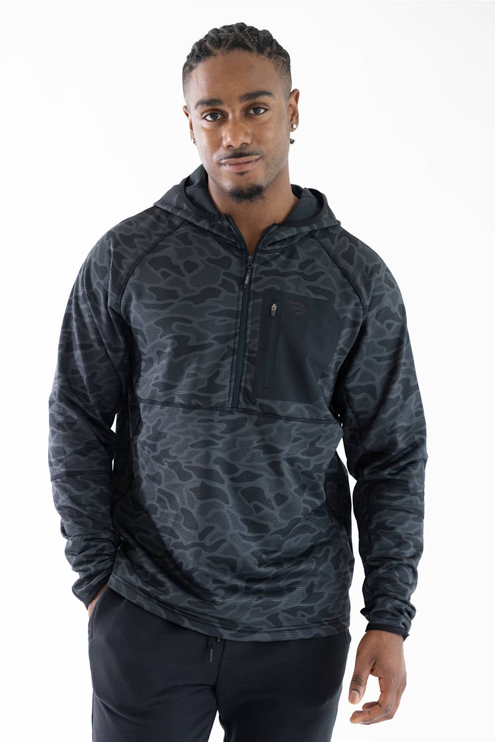 A man wearing a dark gray and black camouflage patterned quarter-zip hoodie with a chest pocket, photographed against a solid white background.