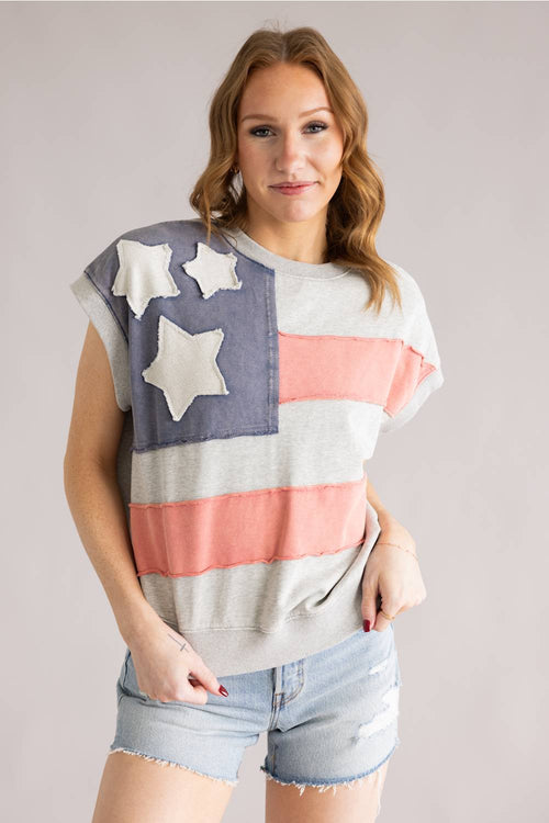 Woman wearing a flag-themed shirt with stars on a plain background