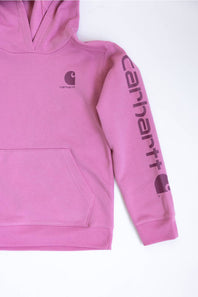 A pink Carhartt pullover hoodie laid flat on a white background, featuring a dark pink Carhartt logo on the left chest and a large vertical Carhartt script logo on the right sleeve.