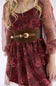 A close-up of a model wearing a dark red floral dress with a wide brown leather belt featuring a gold buckle.