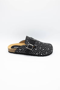 A single black clog-style mule sandal with white polka dots, a black adjustable strap with a silver buckle, and a cork-look midsole, shown against a plain white background.