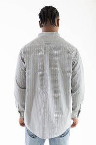 A man viewed from behind wearing a light gray and white patterned button-down shirt and light blue jeans against a plain white background.
