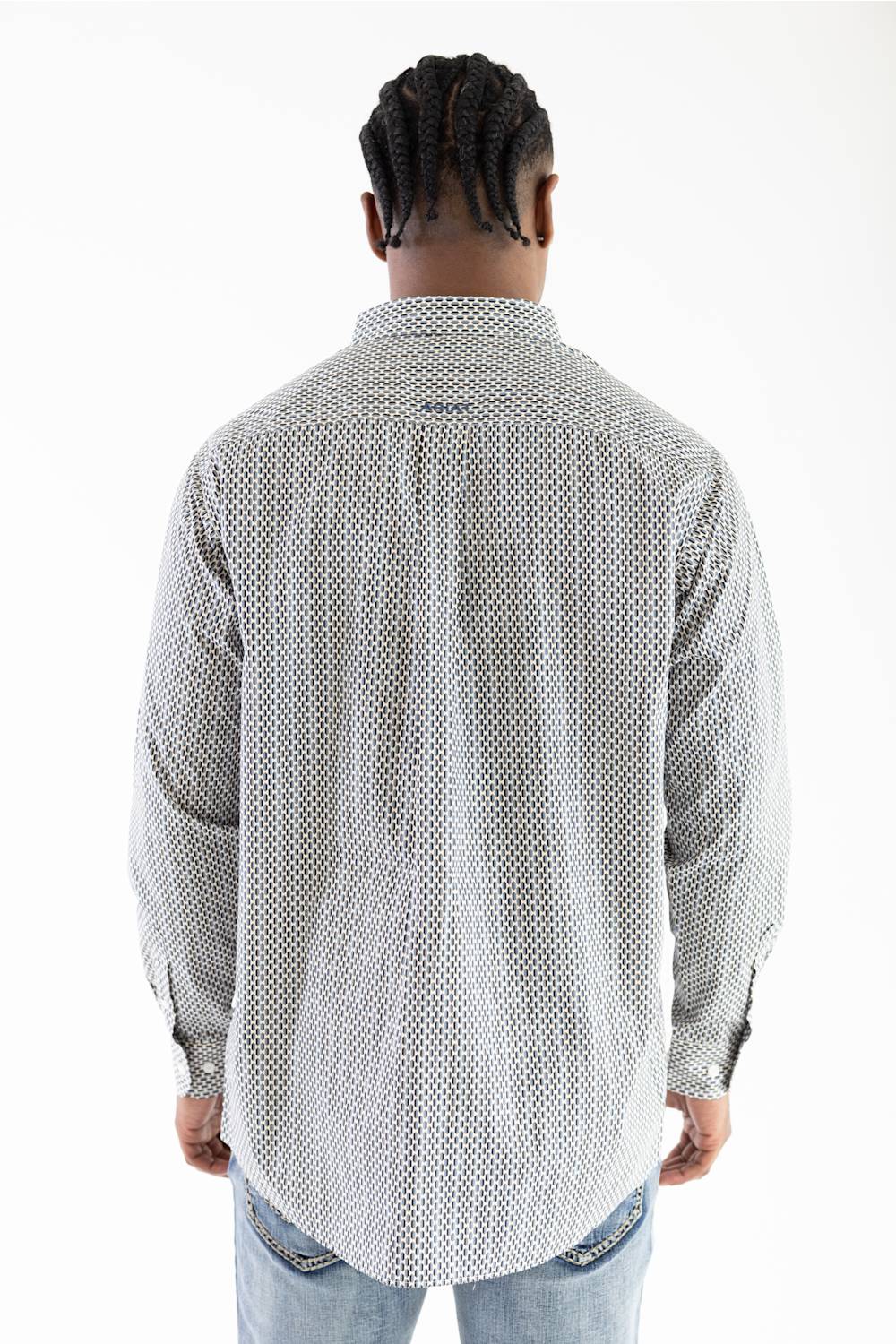A man viewed from behind wearing a light gray and white patterned button-down shirt and light blue jeans against a plain white background.