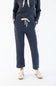 A person wearing a matching navy corduroy lounge set with a drawstring hoodie and cropped pants, paired with white sneakers, photographed against a clean white studio background.