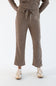 A person wearing corduroy lounge pants in sand-brown with a leopard-print drawstring, paired with a matching top and beige sneakers, shown against a plain light background.
