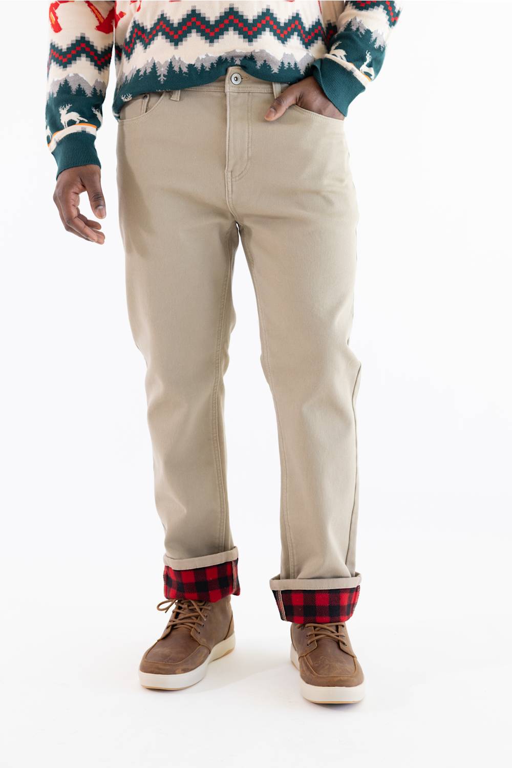A person wearing beige straight-leg pants with red and black plaid cuffs, paired with brown lace-up shoes and a patterned knit sweater, shown from the chest down on a white background.