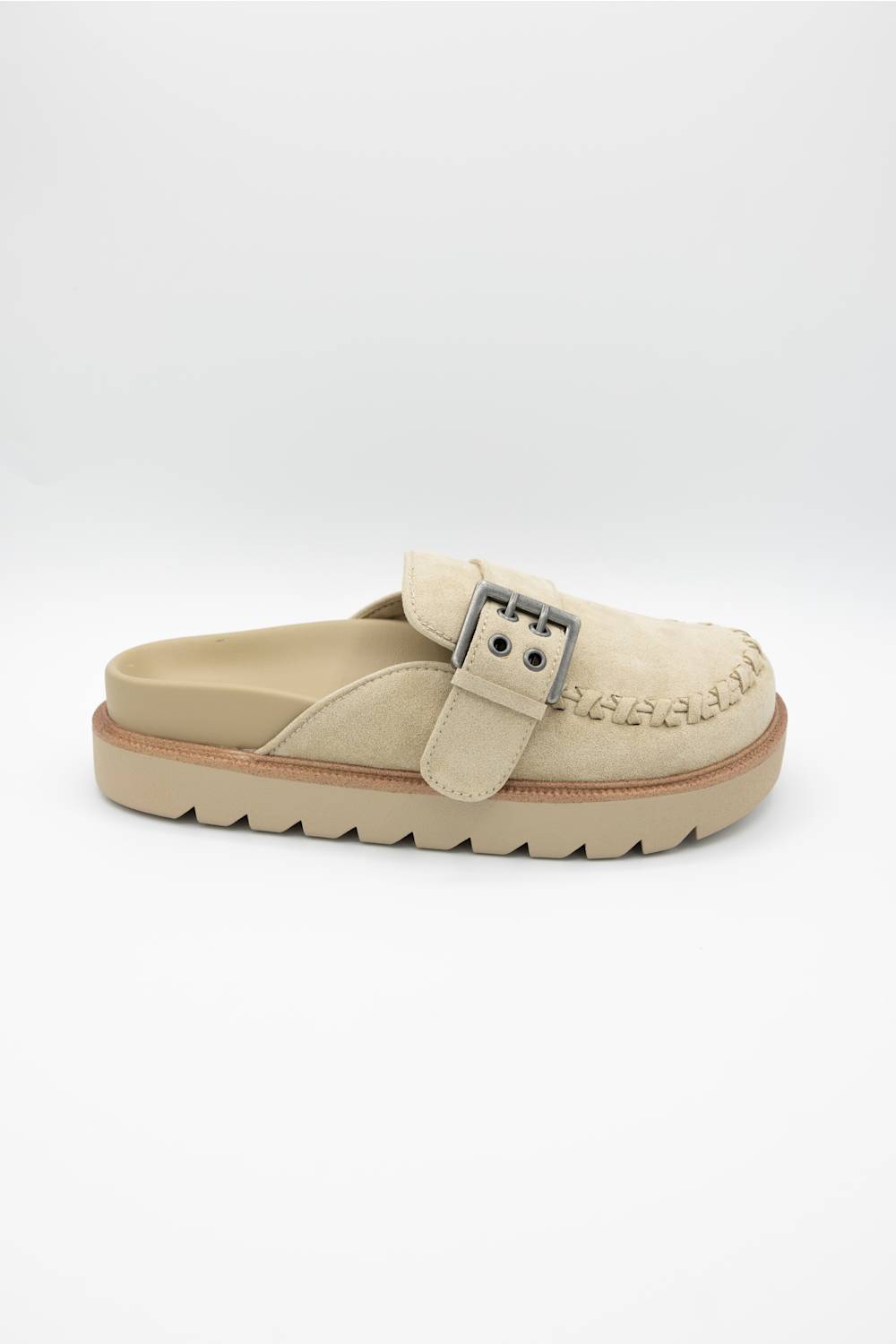 A single beige slip-on clog-style shoe with a braided strap detail and a silver-tone buckle, shown on a light gray background.