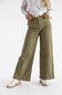 A model wearing olive green wide-leg pants, styled with a light gray cable-knit sweater and white platform boots, standing against a plain white studio background.