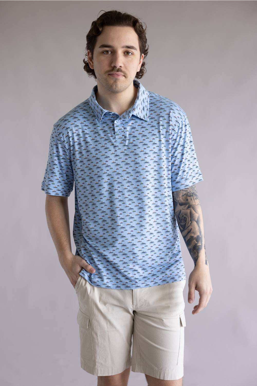 Hallstatt Pontoon Polo for Men in Blue; Man wearing a blue patterned polo shirt and beige shorts against a plain background