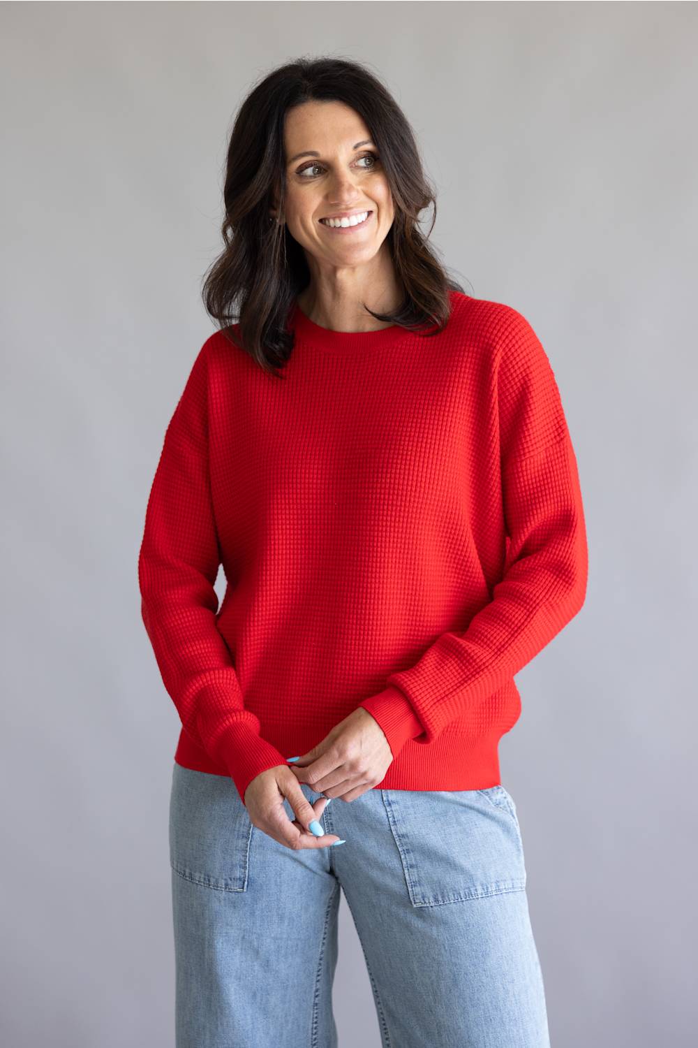 Waffle textured sweater top in a vibrant red color, with thick hems and cuffs 