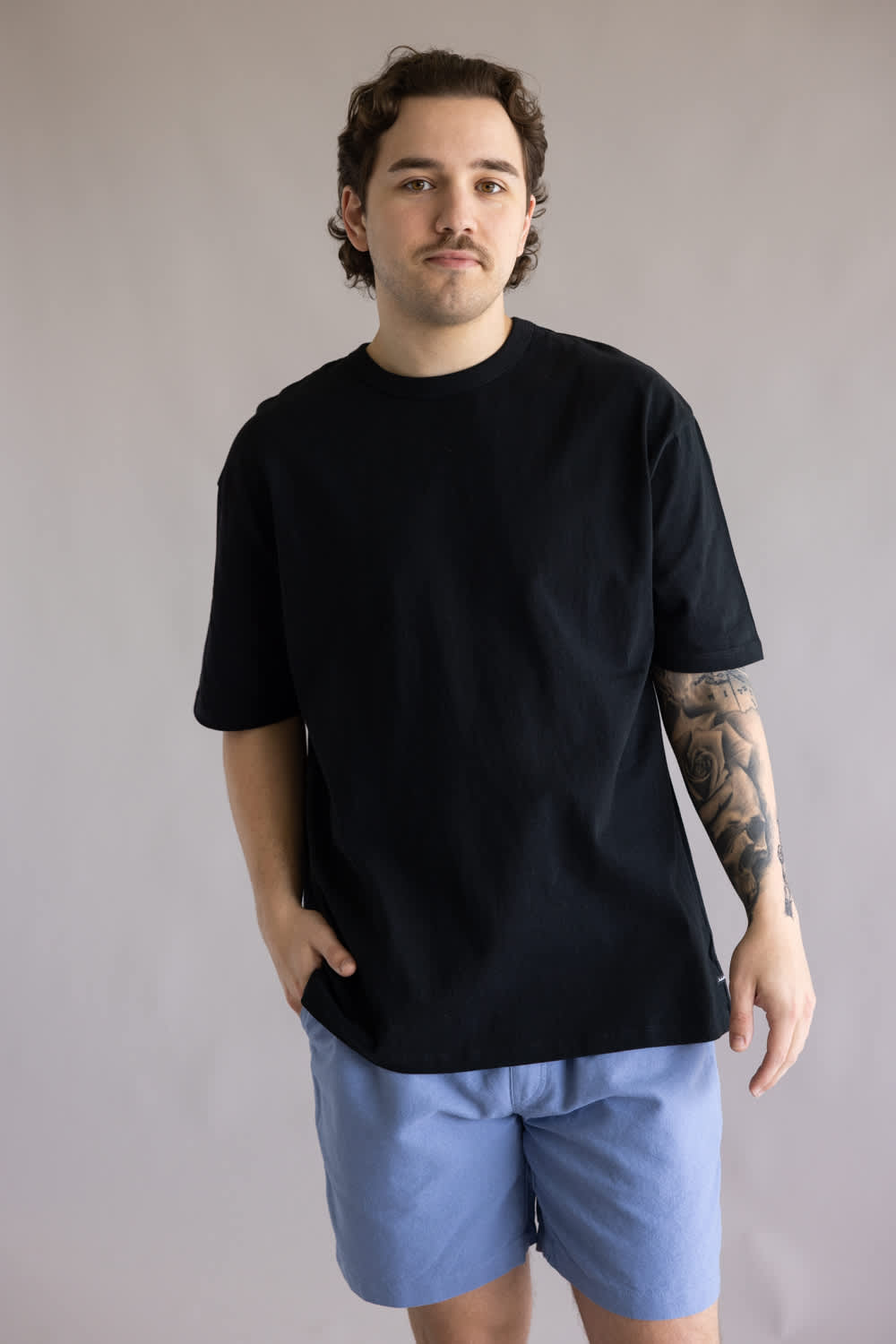 Industrie Del Sur T-Shirt for Men in Black; Man wearing a black t-shirt and blue shorts against a plain background