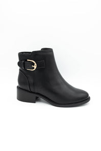 A black leather ankle boot with a low block heel and a decorative strap with a gold buckle on the side, shown against a plain white background.