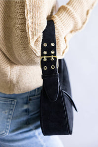 Crescent shaped faux suede shoulder bag with an adjustable buckle detail on strap