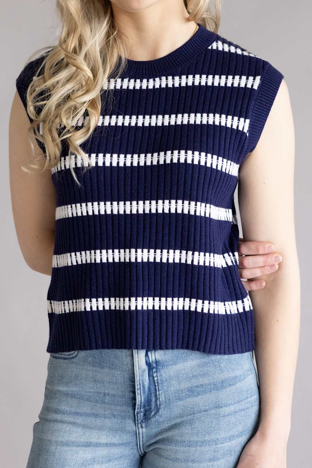 A close-up view of a woman wearing the back of the La Miel Crochet Stripe Top for Women in Galaxy, a striped sleeves knit sweater in navy and white