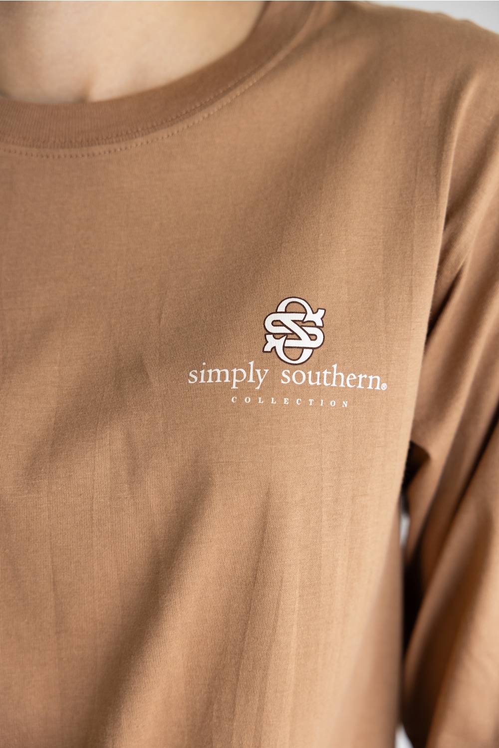 A brown long-sleeve t-shirt with a graphic of three western-style geese on the back, featuring the text 'JUST A SILLY GOOSE' and 'simply southern.' on the back, and 'simply southern.