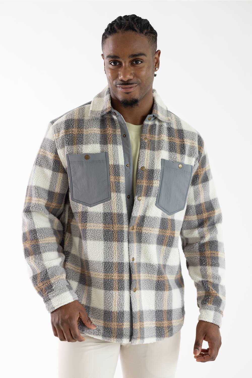 A man wearing a long-sleeve plaid button-up shirt with gray chest pockets, photographed against a plain white studio background.