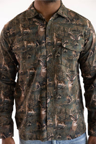 A man wearing a long-sleeve button-up shirt with an all-over woodland deer camouflage pattern in shades of brown, green, and beige.