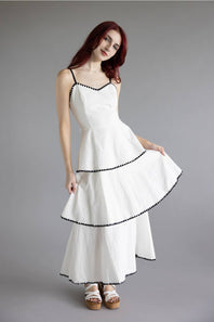 Open Back Tiered Midi Dress for Women in Off White; Woman wearing a white dress with black trim on a gray background
