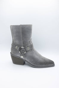A single gray ankle boot with a pointed toe, low stacked block heel, and decorative strap with silver-tone studs and a bow detail on the side, shown against a plain white studio background.