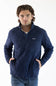 A man wearing a navy blue Patagonia quilted pullover jacket with a stand collar and zippered chest pocket, paired with blue jeans, against a plain white studio background.