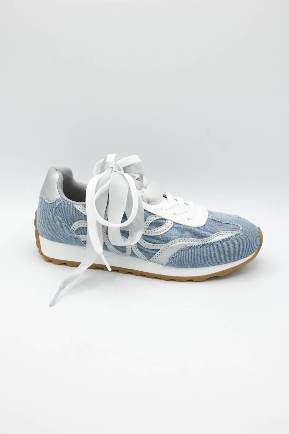 A light blue suede and mesh sneaker with white laces, white midsole, and a brown gum outsole, shown from a side profile on a light gray background.