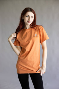 An orange short-sleeve crewneck t-shirt with a small circular logo on the left chest, displayed flat against a white background.