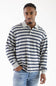 A man wearing a long-sleeve polo shirt with navy blue and white horizontal stripes, paired with light blue jeans, photographed against a plain white studio background.