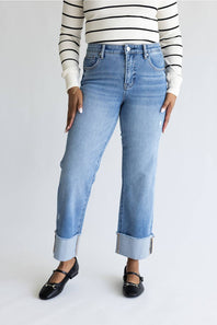 Woman wearing striped shirt with straight leg jeans and cuffed leg. 