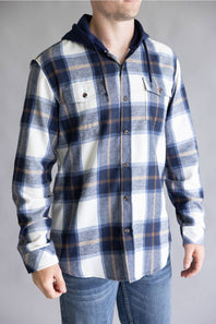 Close-up torso view of a model wearing the Split Men's navy, ecru white, and tan plaid hooded flannel shirt with double chest pockets and dark blue drawstrings against a gray studio background.