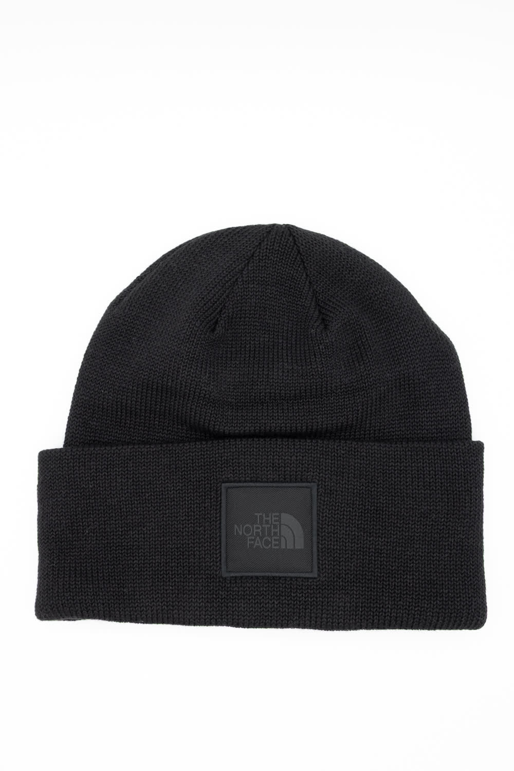 Front view of a black ribbed knit beanie featuring a folded cuff hem with a tonal square patch displaying The North Face logo against a white background.