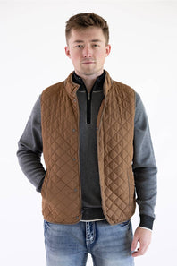Front view of a model wearing a brown rhombus quilted vest, layered over a gray quarter-zip pullover and blue jeans.