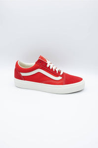 A red Vans Old Skool sneaker with a white side stripe, white laces, and a white rubber sole, photographed on a light gray studio background.