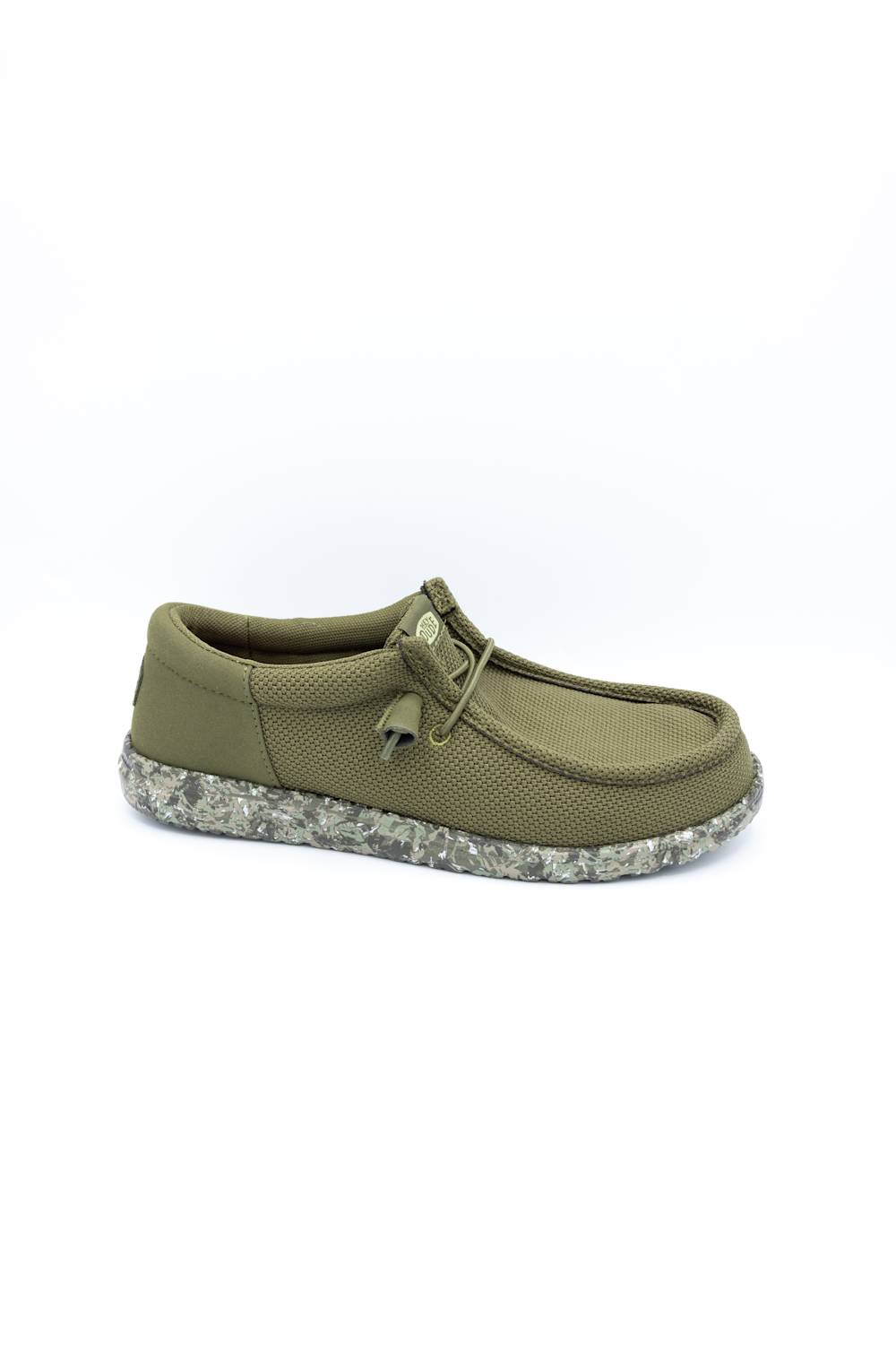 An olive green slip-on shoe with a textured canvas upper, matching fabric laces, and a speckled gray and white sole, shown against a plain white background.