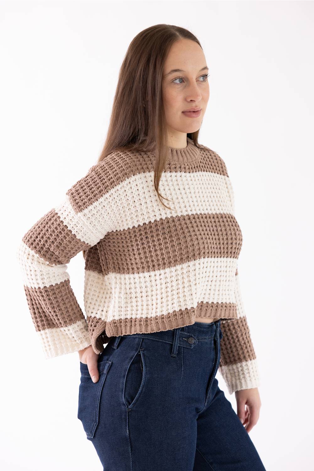 Pink Rose Wide Striped Sweater for Women in Tan/White wearing a wide tan-and-white-striped crewneck sweater with long sleeves, paired with dark blue jeans.