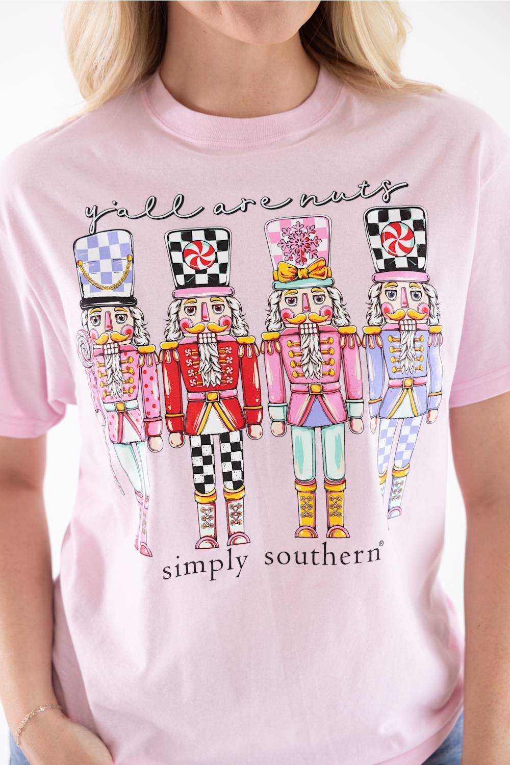 Blonde woman modeling a shirt that reads "yall are nuts" with nutcrackers below it 