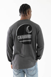 A man viewed from behind wearing a dark gray heather long-sleeve t-shirt with a large black and white Carhartt logo graphic on the back, paired with light blue jeans.